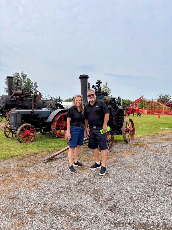 Fred Drodge and a companion in front of an antique steam tractor